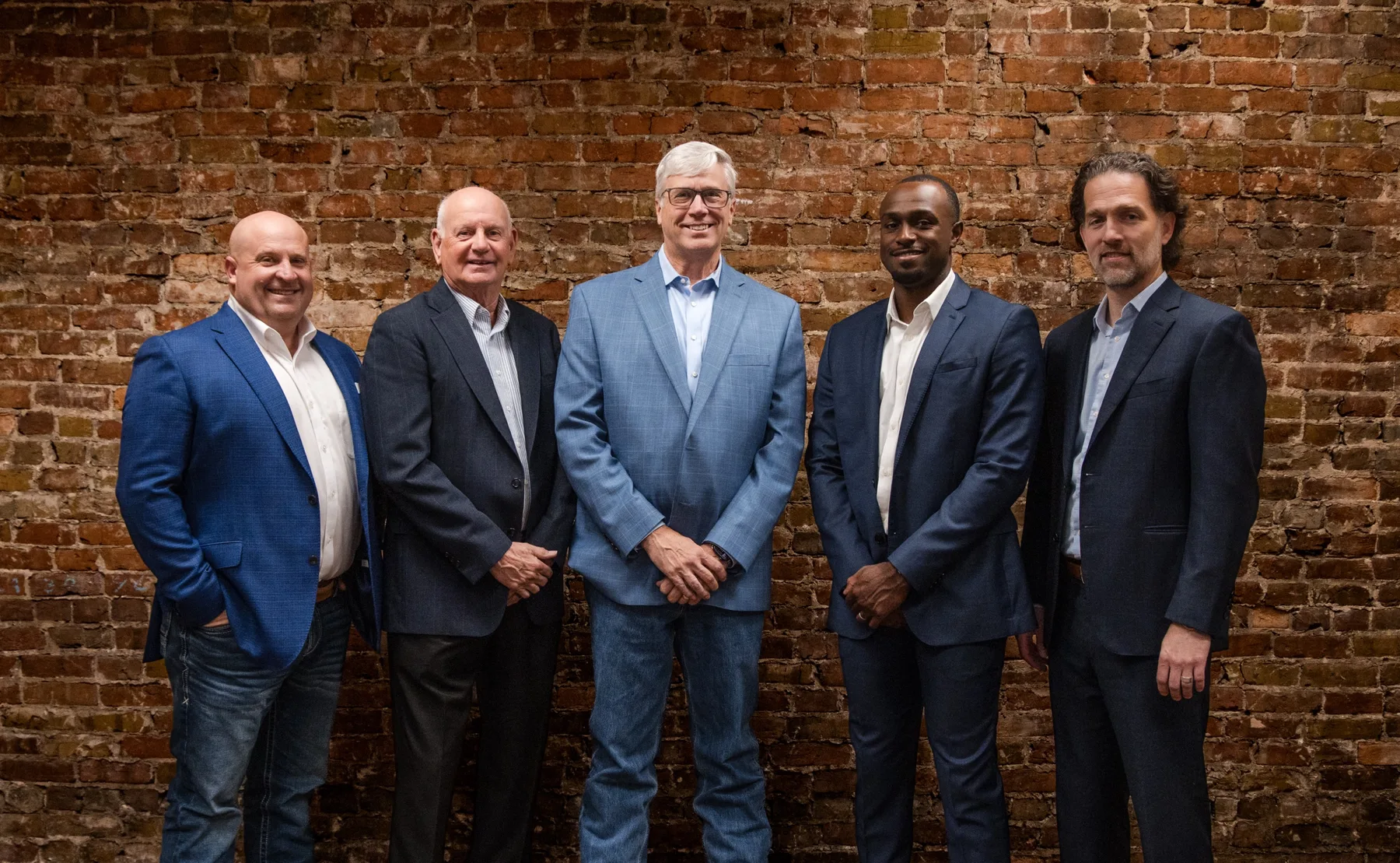 The Caprock team standing together in front of a brick wall